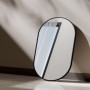 Ovaler Emke Badspiegel mit schwarzem Metallrahmen, an heller Wand lehnend. Moderner Wandspiegel.