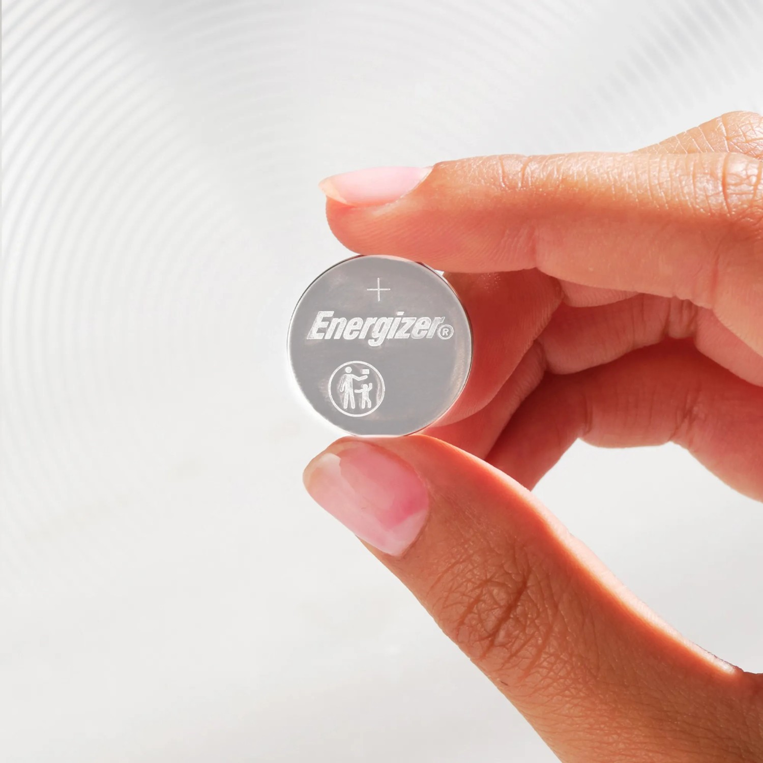Nahaufnahme einer Energizer CR2016 Lithium Knopfzelle in einer Hand.