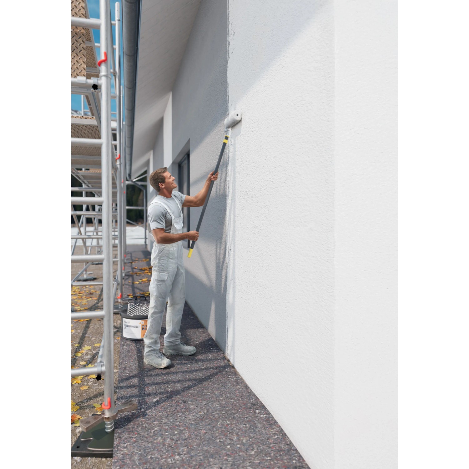 Handwerker streicht Fassade mit Profidur Fassadenprotect 510 Weiß und Farbroller.