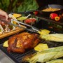 Pit Boss Kombi-Grill mit Hähnchen, Maiskolben und Tacos auf Grillfläche. Vielseitige Grillstation.