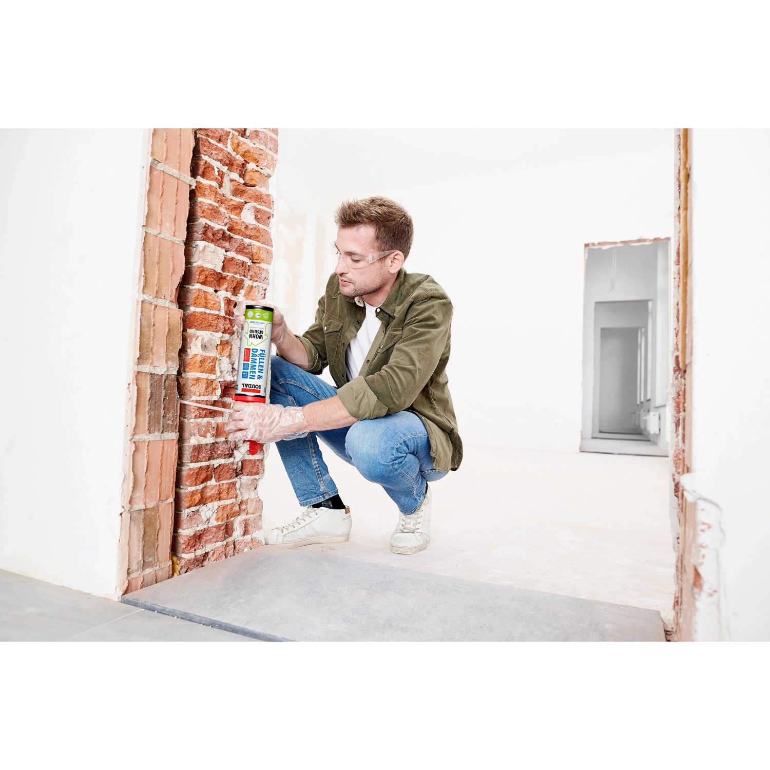 Handwerker füllt mit Soudal Füllen & Dämmen B2 PU-Schaum einen Mauerdurchbruch.