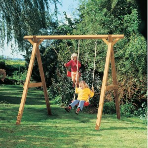 Winnetoo Schaukelbalken 290 cm aus Holz mit zwei Kindern auf Schaukeln im Garten.