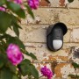 Schwarzer, kabelloser Yale Bewegungsmelder Smart Alarm Außen an einer Backsteinwand.
