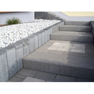 Graue Rechteck-Palisade als Beeteinfassung und Stufenstein für Gartentreppe.