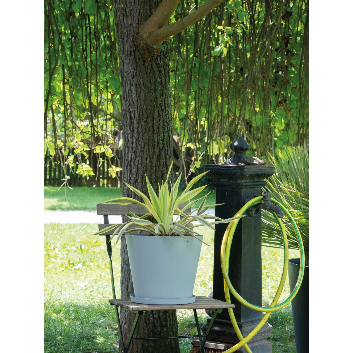Heller, grauer Deroma Pflanztopf (20 cm) der Serie Origin Plant Pot im Garten.