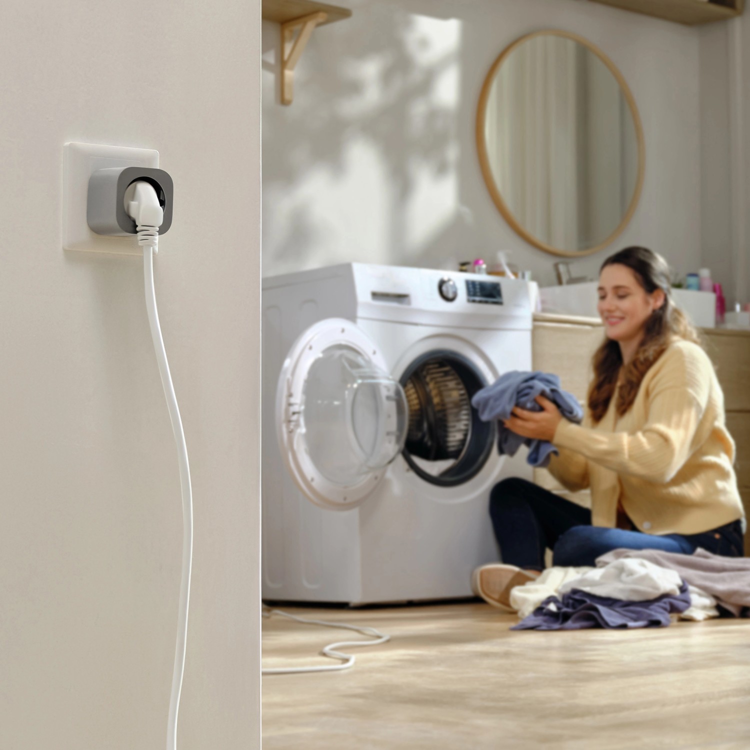 EcoFlow Smart Plug in Silber an Steckdose, mit Waschmaschine im Hintergrund.
