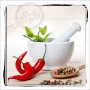 Glasbild Hot & Spicy: Mörser, Chili, Pfeffer und Minze auf Küchenbild, 30x30 cm.