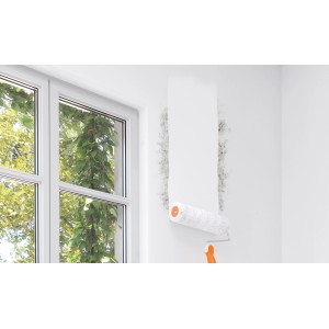 Anwendung von Alpina Schimmel Blocker: Weiße Farbe wird mit Farbroller auf Wand mit Schimmel aufgetragen.