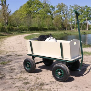 Grüner Sunny Bollerwagen Billy Beach Wagon mit Luftreifen vor See und Bäumen.