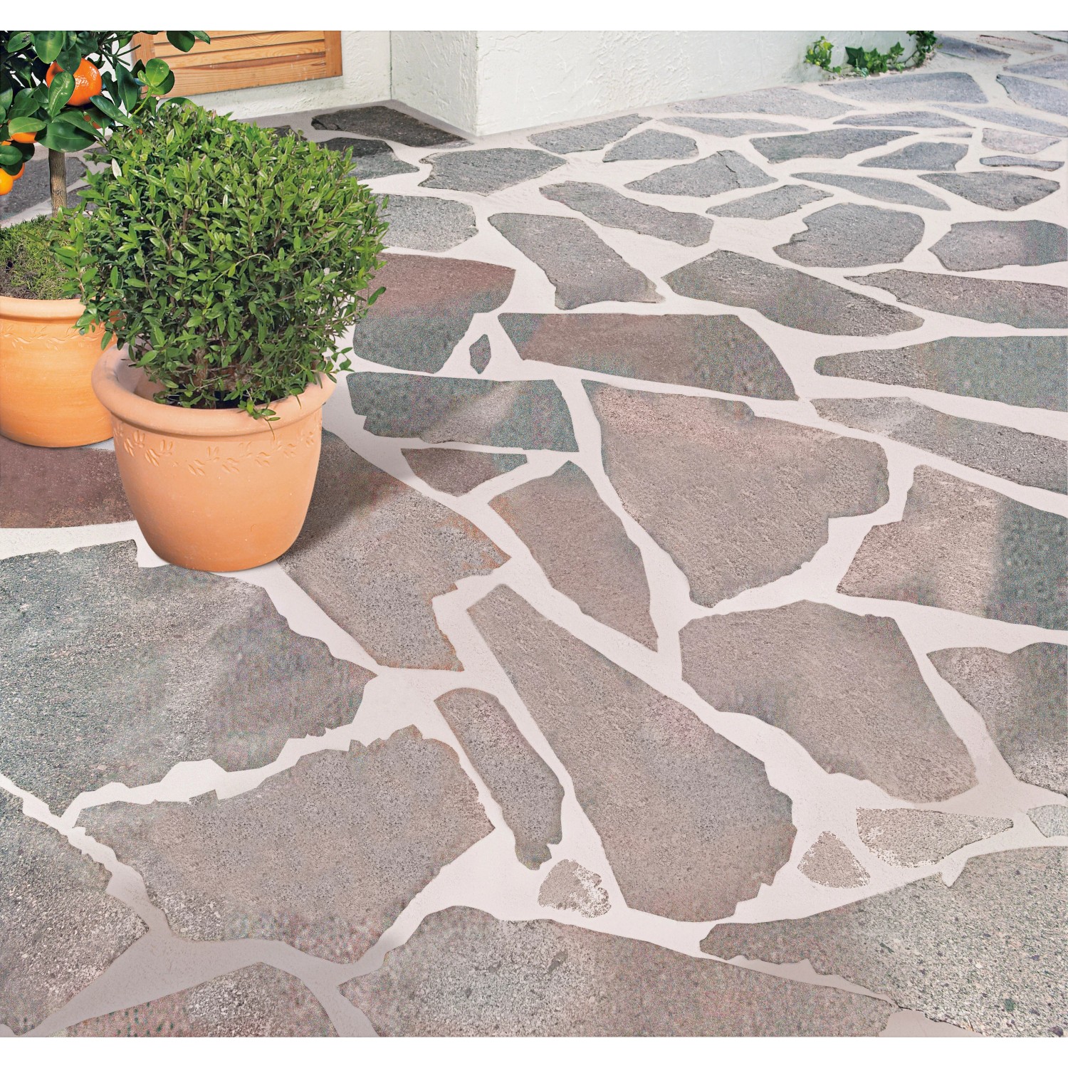 Verlegte Porphyr-Polygonalplatten rot-bunt (Stärke 20-40 mm) als Terrassenplatten mit Pflanzkübel.