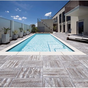 Verlegte Bagattini Megadrain Terrassenplatten Tundra in Braun-Grau um einen Pool.