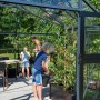 Juliana Gewächshaus Orangerie 21 in Schwarz-Anthrazit mit Familie bei der Gartenarbeit.