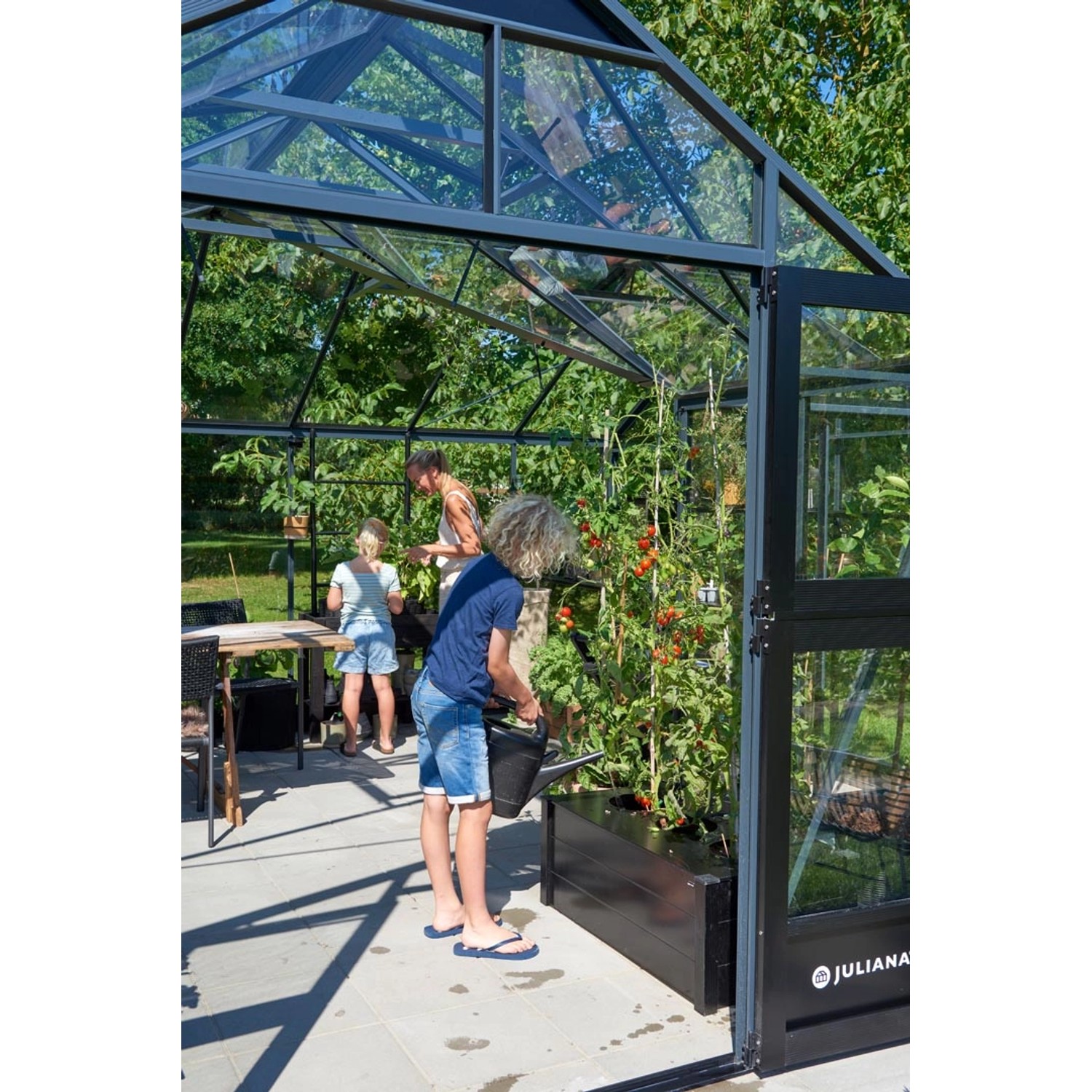 Juliana Gewächshaus Orangerie 21 in Schwarz-Anthrazit mit Familie bei der Gartenarbeit.