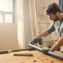 Mann sägt Rohr mit Bosch Akku-Säge NanoBlade AdvancedCut 18. Stichsäge für präzise Schnitte.