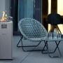 Buschbeck Terrassenheizer Malta Grau mit Glasaufsatz und Flammen, daneben Sitzgruppe.