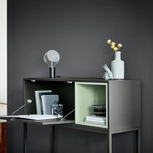 Dekoratives Sideboard in Anthrazit mit Lampe, Vase und Ablagefächern. Wandfarbe: Alpina Stille des Vulkans.