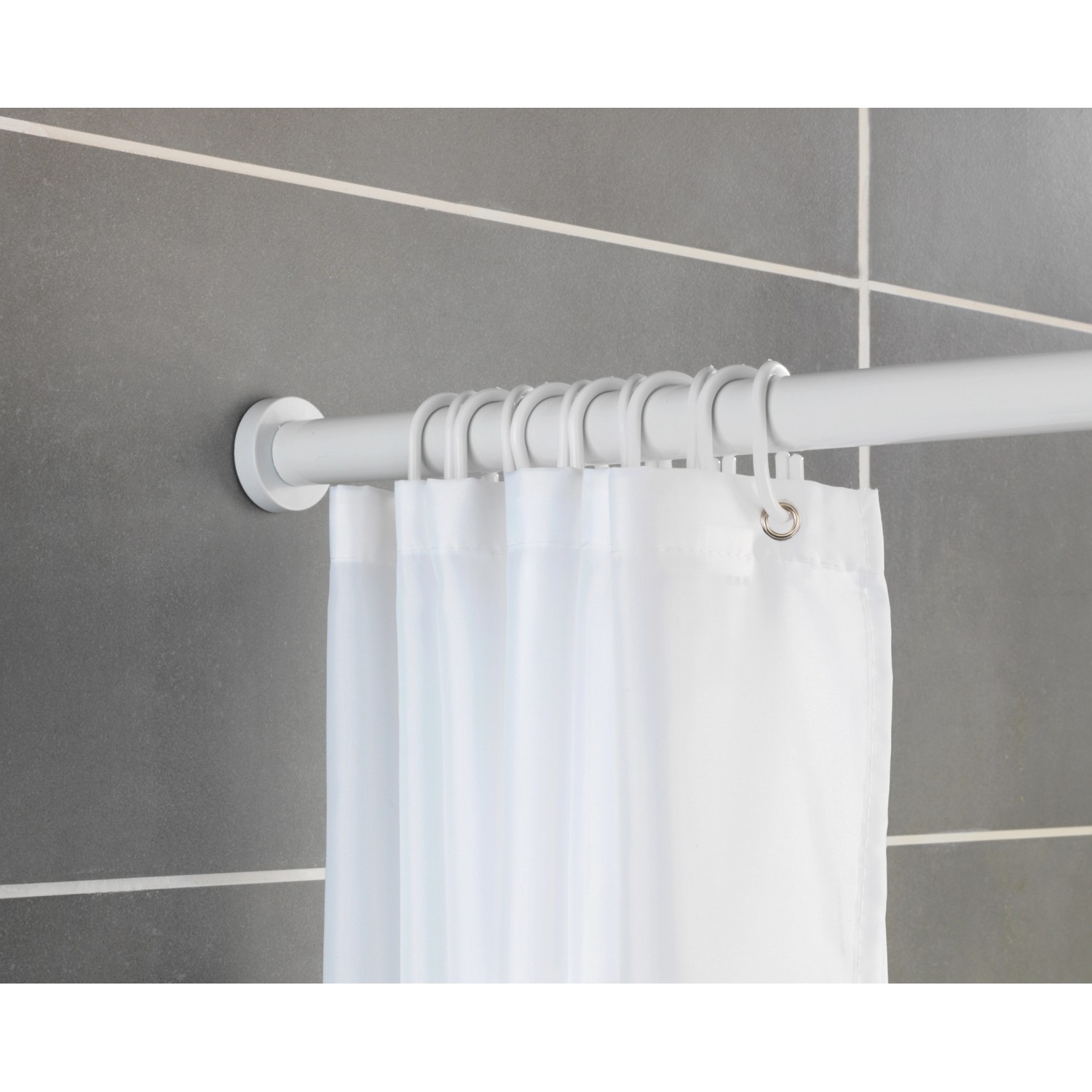 Weiße, ausziehbare Wenko Teleskop-Duschstange Luz mit Duschvorhang und Ringen vor grauer Wand.