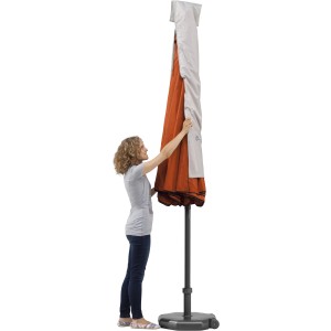 Schneider Schutzhülle für Sonnenschirme bis Ø 300 cm im Einsatz. Frau zieht Hülle über Schirm.