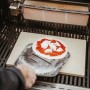 Enders Pizzastein eckig 40x30 cm mit Pizza auf Grill. Grillutensil für knusprige Pizza.