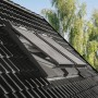 Solar Rollladen aus Aluminium für Velux Dachfenster, geschlossen auf dunklem Ziegeldach.