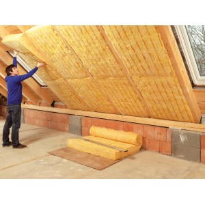 Mann verlegt Isover Multi-Kombi Passivhaus Klemmfilz WLS 033 (100mm) zur Dachdämmung.