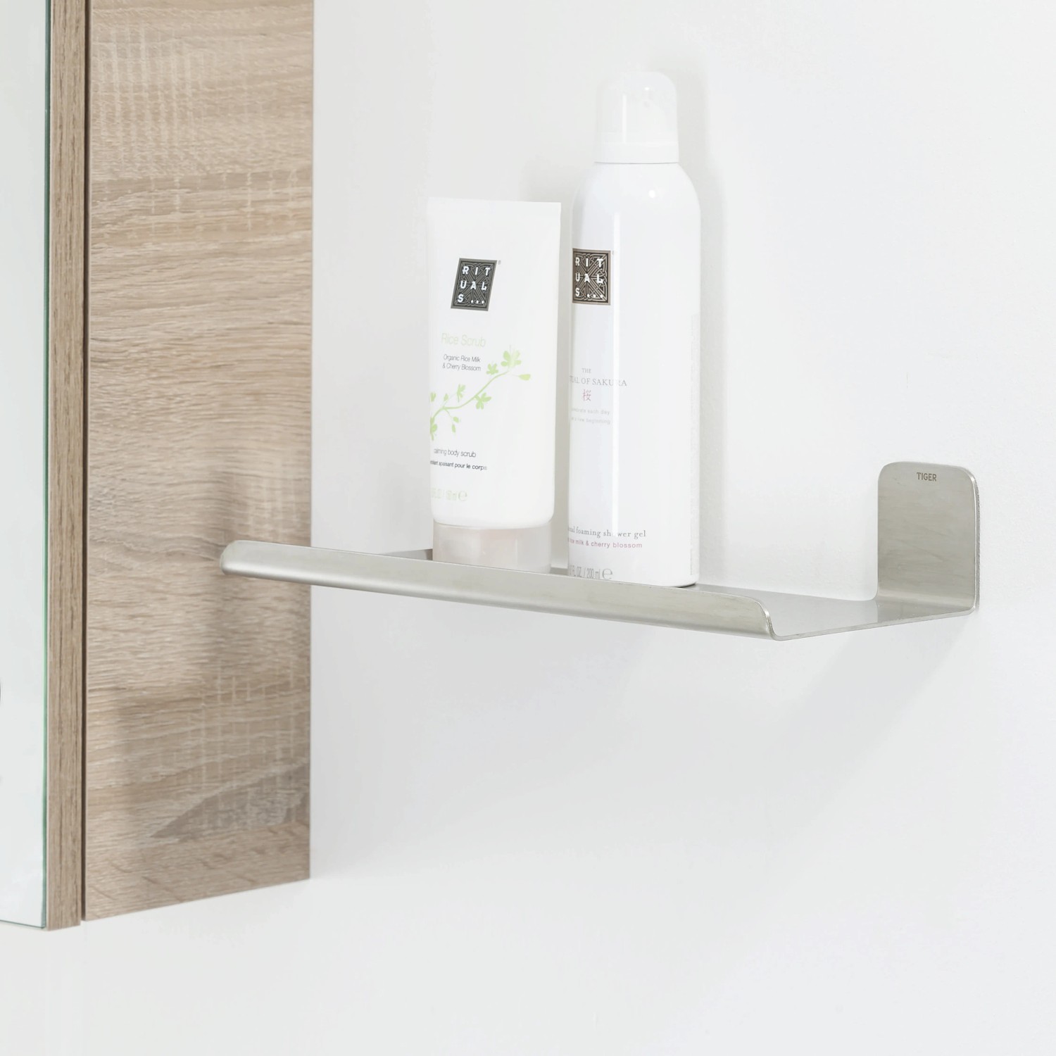 Tiger Colar Ablage, 30cm, Edelstahl gebürstet, mit Badartikeln an der Wand.