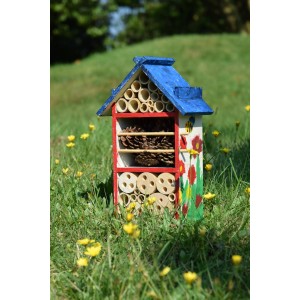 Bemaltes Holz Insektenhotel-Bausatz mit Farben, Pinsel und Füllmaterial im Garten.
