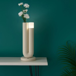 Beige Brilliant LED Tischleuchte Sayu mit integrierter Vase, weißen Blumen, leuchtend auf Regal.