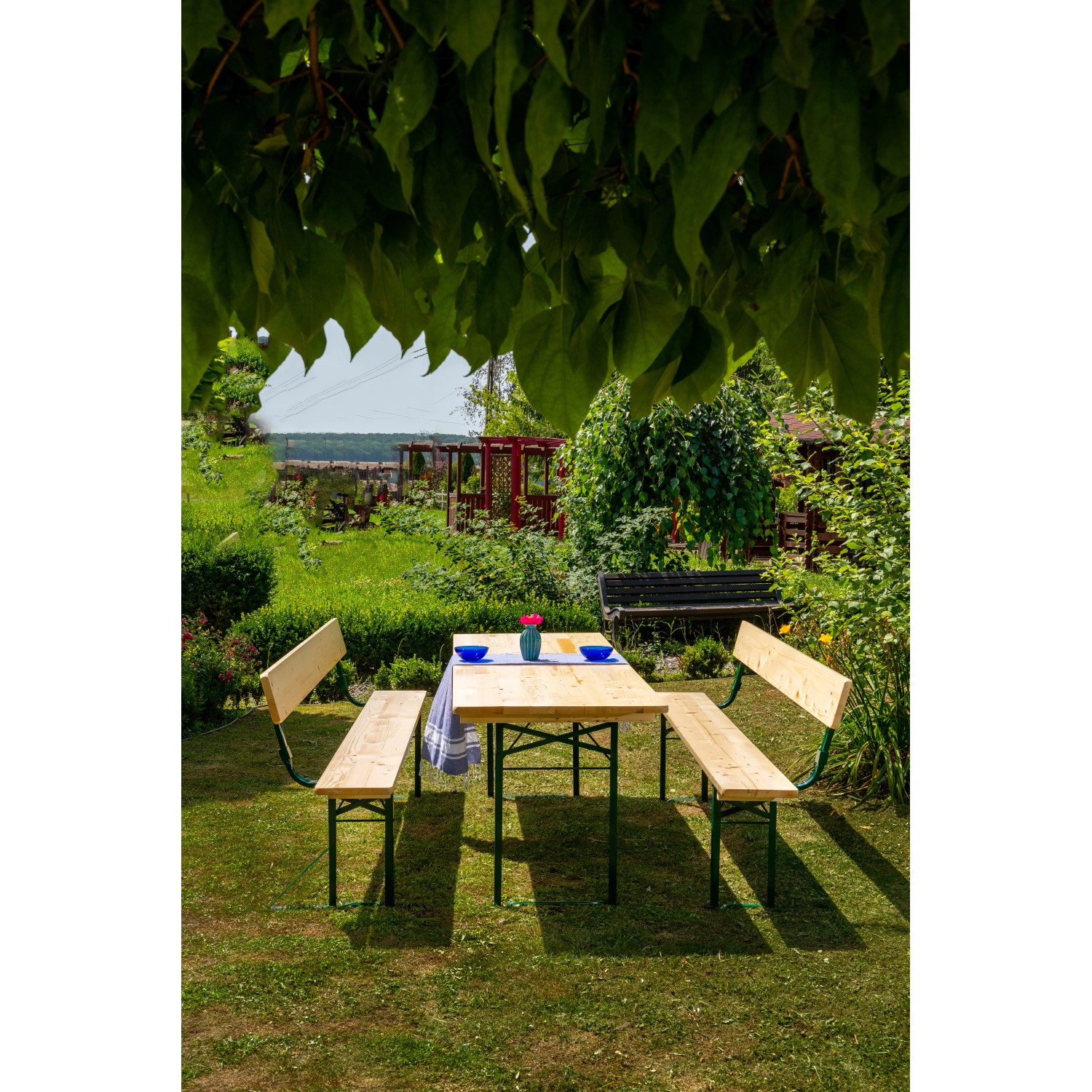 Klappbare Bierzeltgarnitur mit Rückenlehne und breitem Tisch im Garten.