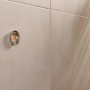 Wandhalterung der Tesa WC-Bürstengarnitur Moon in Bronze an beiger Wand montiert.