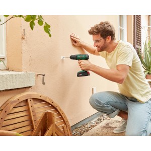 Mann bohrt mit dem Bosch 18V Akku-Schlagbohrschrauber EasyImpact 18V-40 in eine Wand.