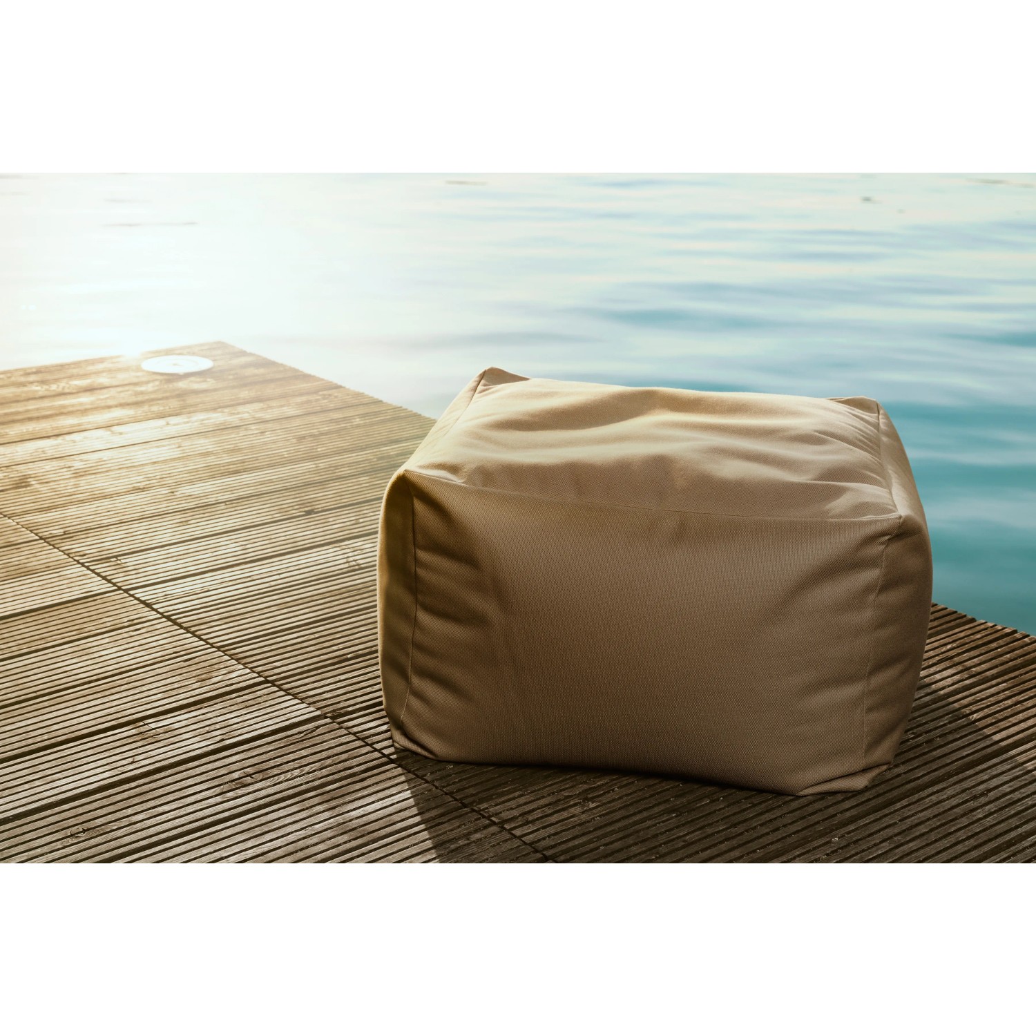 Braunfarbener Sitting Point Hocker Outside (150 l) auf Holzsteg am Wasser.