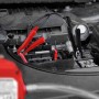 APA Ölabsaugpumpe 12V im Einsatz am Auto, mit Batterieklemmen an der Autobatterie.