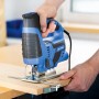 Blaue LUX Stichsäge E-STS-23 beim Sägen von Holz mit Parallelanschlag.