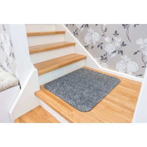 Anthrazitfarbene Astra Sauberlaufmatte Entra auf einer Holztreppe. Saugstarke Fußmatte, ca. 60x75 cm.