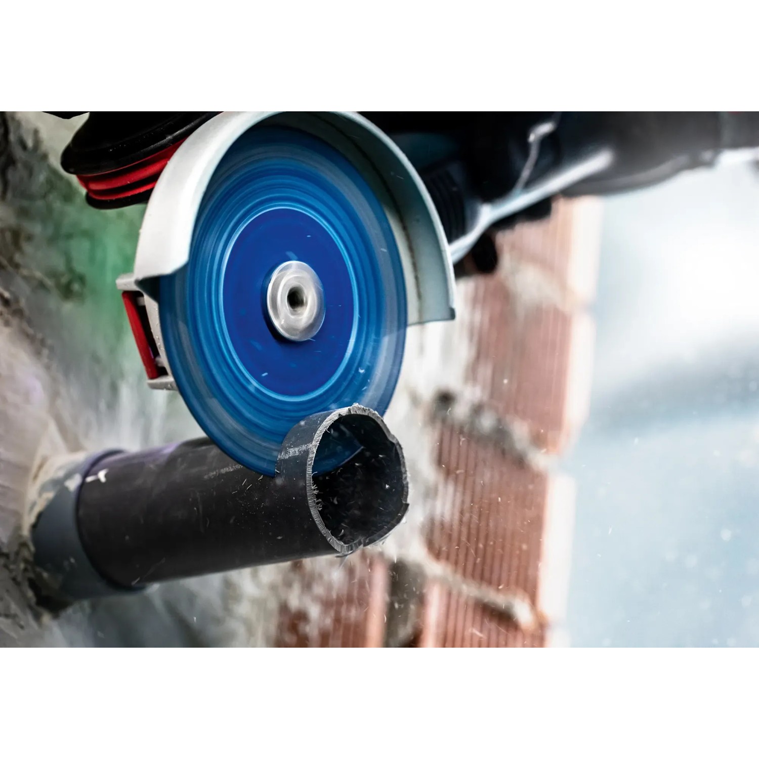 Bosch Expert Trennscheibe im Einsatz: Winkelschleifer schneidet Kunststoffrohr. Zubehör für vielseitige Anwendungen.