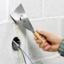 Hand hält LUX Malerspachtel (100mm) zum Glätten von Spachtelmasse an einer Wand.