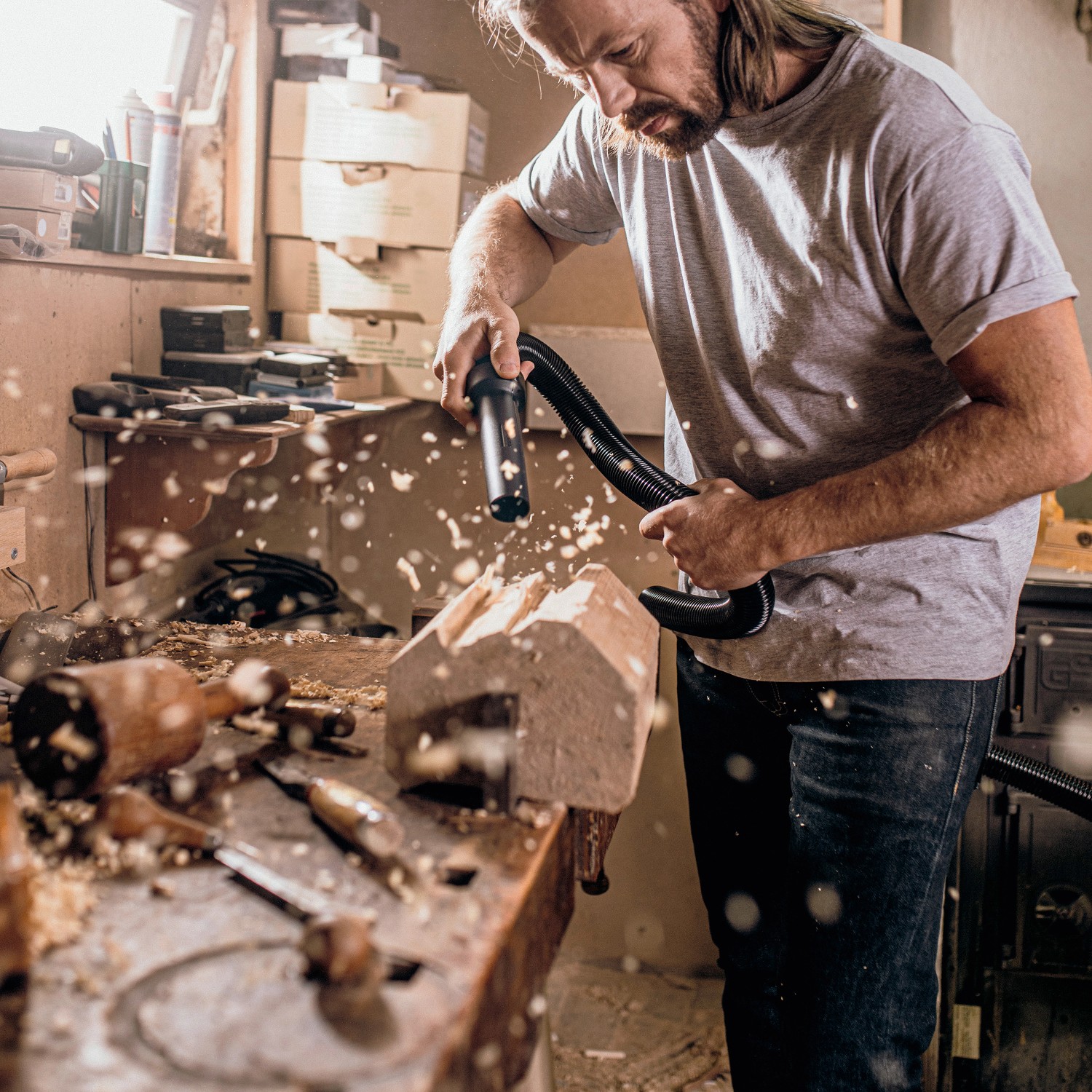 Mann reinigt Werkstück mit Kärcher Akku Nass-Trockensauger WD 2-18 in Werkstatt.