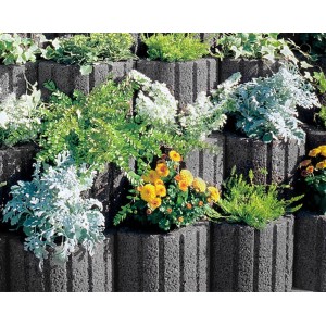 Graue Pflanzringe Mini, bepflanzt mit bunten Blumen und Pflanzen.