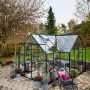 Halls Gewächshaus Garden Room, 12,9 m², grüne Aluminiumstruktur mit Glas, im Garten.