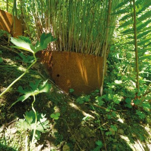 Bellissa Hangpflanzschale Collina Corten zur Hangbefestigung mit Bepflanzung im Garten.
