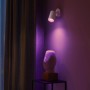 Philips Hue Fugato LED-Spot, 1-flammig, Weiß, mit farbigem Licht an der Wand.