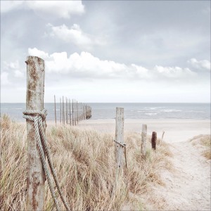 Glasbild Oase der Sinne mit Strand, Meer und Holzpfosten, 20x20cm.