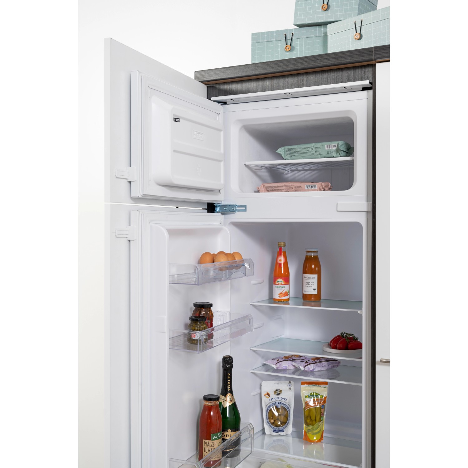 Offene Kühl-Gefrierkombination der Respekta Premium Küchenzeile, gefüllt mit Lebensmitteln.