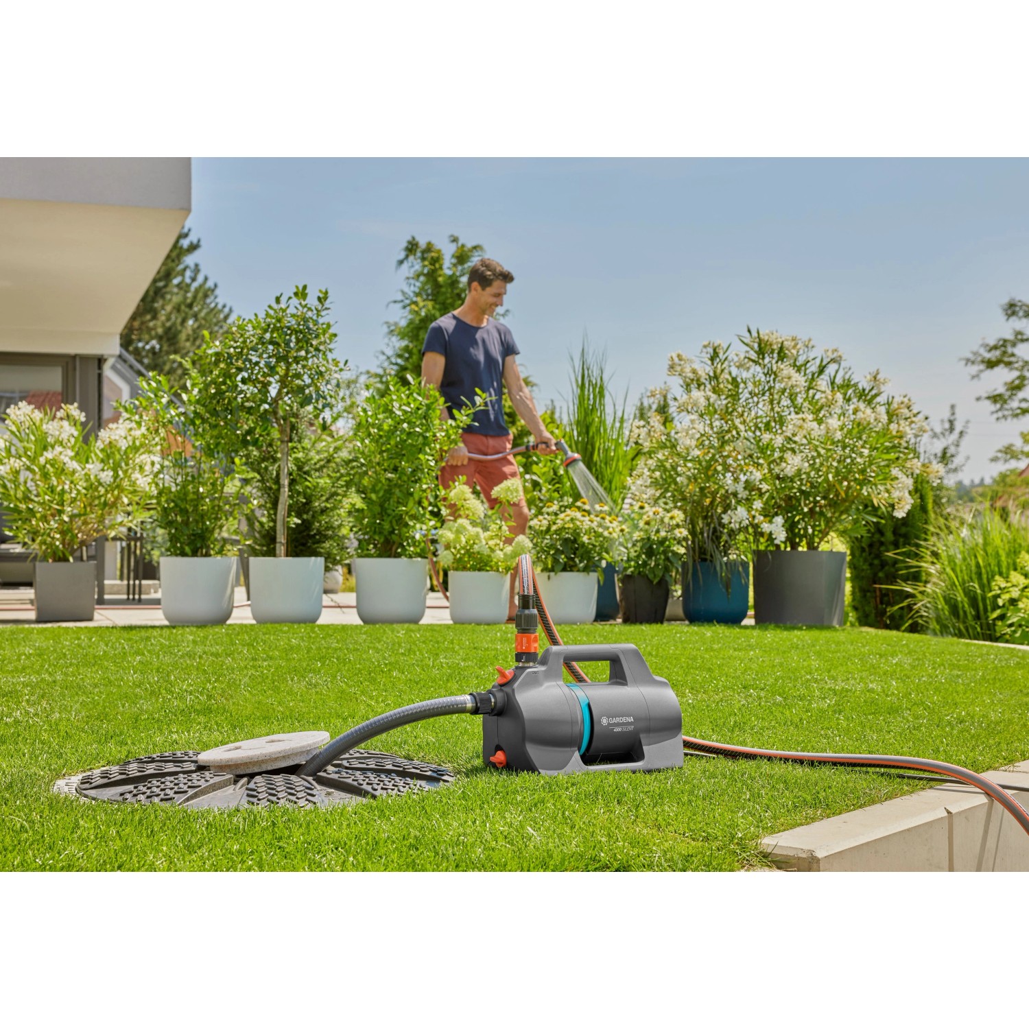 Gardena 4300 Silent Gartenpumpe im Einsatz: Mann bewässert Pflanzen mit der leisen Elektropumpe.