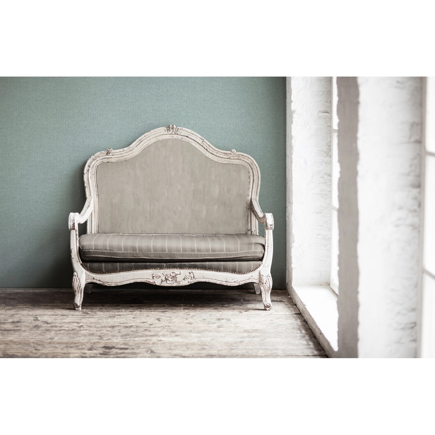 Türkise Vliestapete mit Muster an Wand hinter antikem Sofa. Dekorative Tapete.