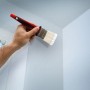 Hand streicht Wand mit Flachpinsel aus dem 6-teiligen Pinsel-Set. Roter Kunststoffgriff.