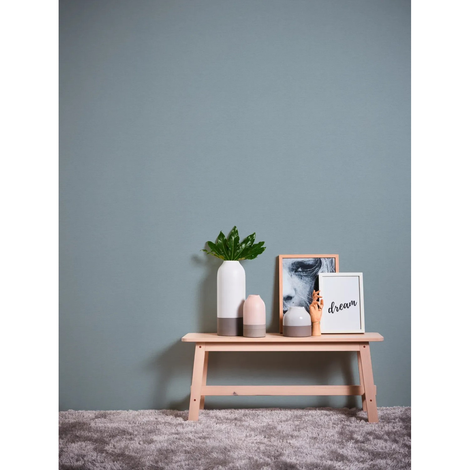 Blaue, leicht strukturierte Vliestapete Uni Matt von OBI an Wand hinter Deko.