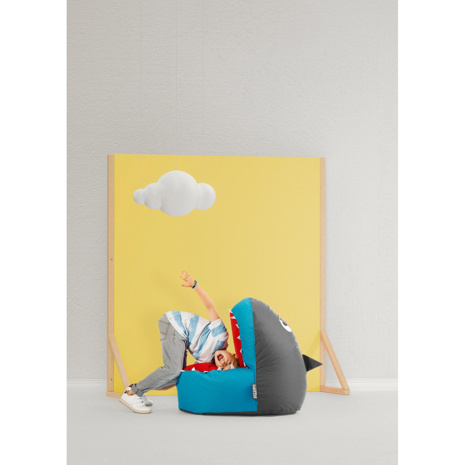 Bunter Sitzsack Shark Brava von Sitting Point in Haifischform mit Kind.
