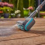 Gardena AquaBrush Universal Akku-Multi-Reiniger in Aktion auf Holzterrasse.